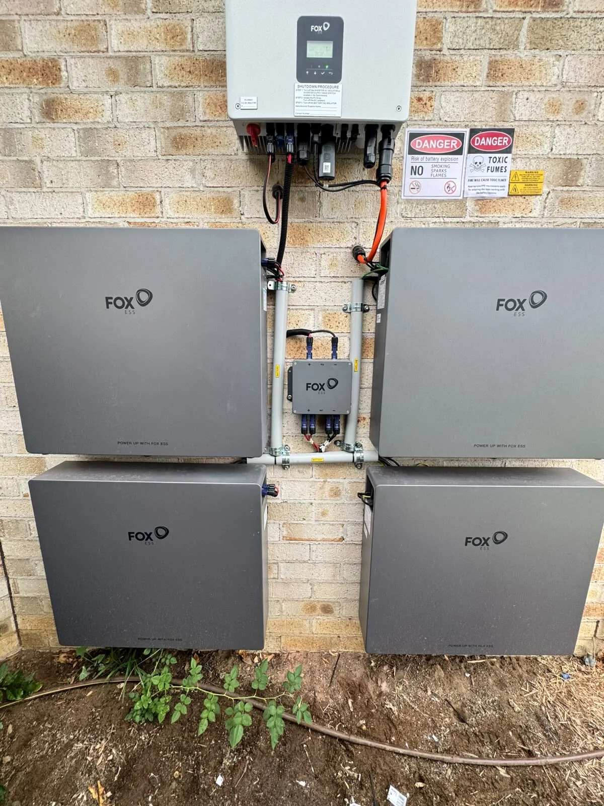 FoxESS inverter and four battery modules installed on a brick wall