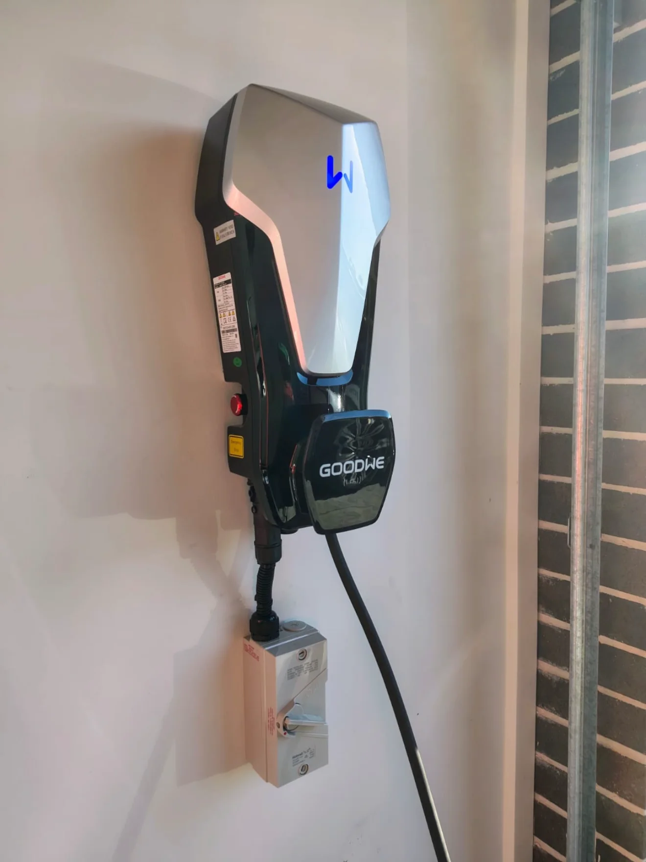 A GoodWe home EV charger installed on a garage wall